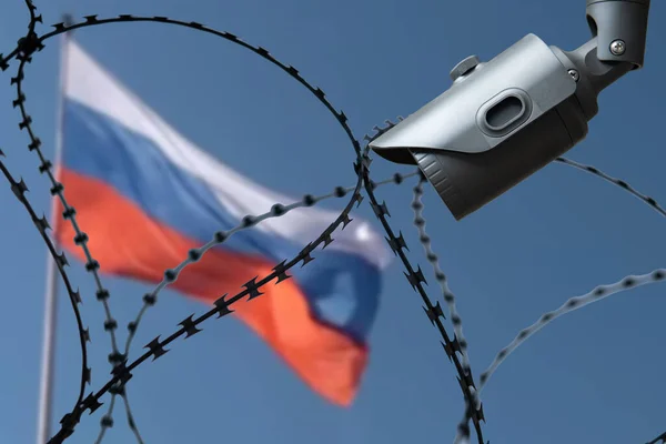 ロシアの国旗を背景に防犯カメラ付きの鉄条網 — ストック写真