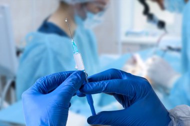 Close up man doctor holding syringe. Doctor in surgical mask and gloves preparing syringe for injection