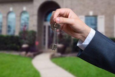 Yeni evin anahtarlarına parmak üzerinde tutan adam el