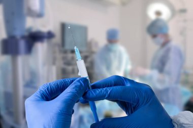 Close up man doctor holding syringe. Doctor in surgical mask and gloves preparing syringe for injection