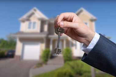 Yeni evin anahtarlarına parmak üzerinde tutan adam el