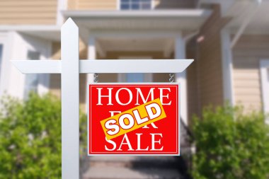 Satılık Emlak işareti önünde güzel bir yeni ev için satılan ev