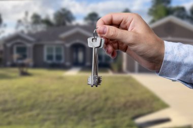 Yeni evin anahtarlarına parmak üzerinde tutan adam el