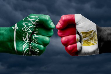 SAUDI ARABIA EGYPT karşı karşıya, dini çatışma. SAUDI ARABIA ve EGYPT 'nin boyanmış bayraklarıyla erkeklerin yumrukları
