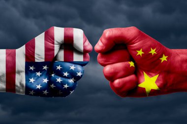 ABD, Çin 'e karşı çatışma, din çatışması. ABD ve Çin 'in boyanmış bayraklarıyla erkeklerin yumrukları