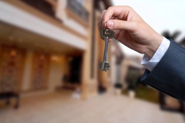 Yeni evin anahtarlarına parmak üzerinde tutan adam el