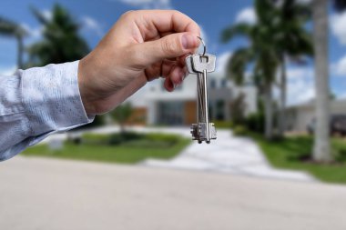 Yeni evin anahtarlarına parmak üzerinde tutan adam el