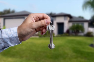 Yeni evin anahtarlarına parmak üzerinde tutan adam el