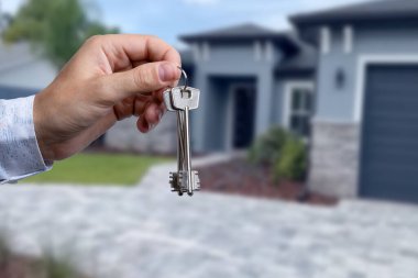 Yeni evin anahtarlarına parmak üzerinde tutan adam el