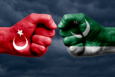 TURKEY, PAKISTAN 'a karşı mücadele, dini çatışma. TurkEY ve PAKISTAN 'ın boyanmış bayraklarıyla erkeklerin yumrukları