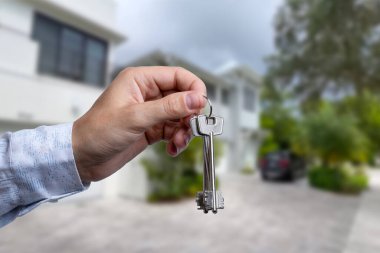 Yeni evin anahtarlarına parmak üzerinde tutan adam el