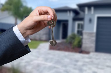 Yeni evin anahtarlarına parmak üzerinde tutan adam el