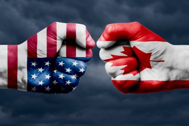 ABD 'ye karşı CANADA çatışması, din çatışması. Kanada ve ABD bayrakları boyalı erkek yumrukları. Koyu bulutlar