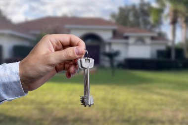 Yeni evin anahtarlarına parmak üzerinde tutan adam el