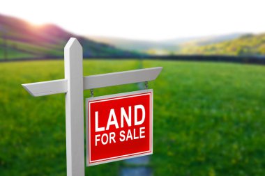 Satılık arazi. Yeşil çimlerin üzerinde satılık arazi tabelası. Arazinin satın alınması. Boş arazi satın almak. Ev inşaatı için alan. Kırpılmış çimen arka planında reklam zeminini imzala