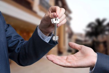 Emlakçıyla yeni sahibi arasındaki ev anahtarlarını vermek. satış kavramı