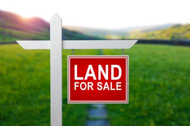 Satılık arazi. Yeşil çimlerin üzerinde satılık arazi tabelası. Arazinin satın alınması. Boş arazi satın almak. Ev inşaatı için alan. Kırpılmış çimen arka planında reklam zeminini imzala