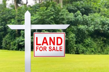 LAND FOR SALE SIGN on empty meadow - Real estate conceptual image clipart