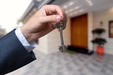 Yeni evin anahtarlarına parmak üzerinde tutan adam el