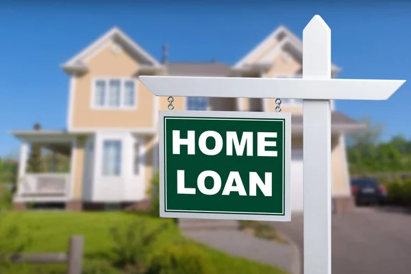 HOME LOAN sign against a house. Close-up