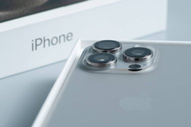 Apple iPhone 15 Pro Max, üçlü kameralı akıllı telefon, tarafsız gri arka planda temiz ve izole bir şekilde görüntülendi.