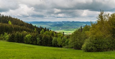 Bile Karpaty dağlarında Pozar Tepesi 'nin çayırlarında Valaske Prikazy köyü ve Vizovicke Vrchy Dağları' nın arka planında baharda görülecek manzara