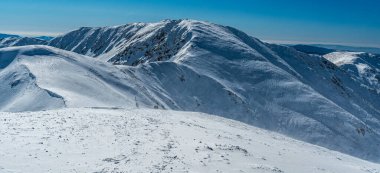 Partly rocky Skalka hill from Kotliska hill in Low Tatras in Slovakia during beautiful winter day clipart