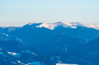 Velka Fatra 'daki Ostredok tepesi Slovakya' nın Mala Fatra dağlarındaki Mincol tepesinden açık gökyüzüne sahip kış günü boyunca uzanır.