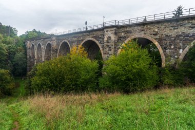 Almanya 'nın Plauen şehrinde Syratal üzerinde ağaçlarla çevrili tuğla demiryolu köprüsü