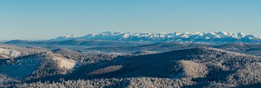 Nearer hills of Beskids mountains, part of Oravska Magura mountains and Tatra mountains from Velka Raca hill in winter Kysucke Beskydy mountains clipart
