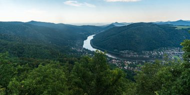 Labe river valley with hills of Ceske stredohori mountains around from Vysoky Ostry hill near Usti nad Labem city in Czech republic during beautiful summer day clipart