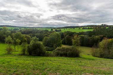 Almanya 'nın Vogtland bölgesindeki Oelsnitz kasabası yakınlarındaki çayırların, ormanların ve küçük tepelerin karışımıyla sonbaharın başlarında kayan manzara