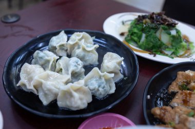 Siyah tabakta Çin buğulama köftesi ve garnitür..