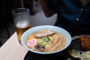 Restoran masasında biralı Japon baharatlı ramen