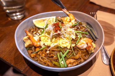 Pad Thai bir Tayland eriştesi kızartmasıdır. Yanında da ezilmiş fıstık ve tatlı-ekşi sos vardır..