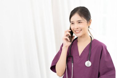 Mutlu Asyalı kadın doktor hastayla telefonla konuşuyor. İyi olduğunu duyduğuma sevindim. Mutlu kadın doktor neşeli bir konuşma yapıyor. tıp, teknoloji ve sağlık hizmetleri kavramı.