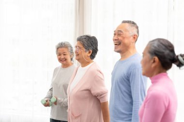 Bir grup aktif Asyalı son sınıf öğrencisi egzersiz yapıyor. Bir grup yaşlının fitness dersi var..