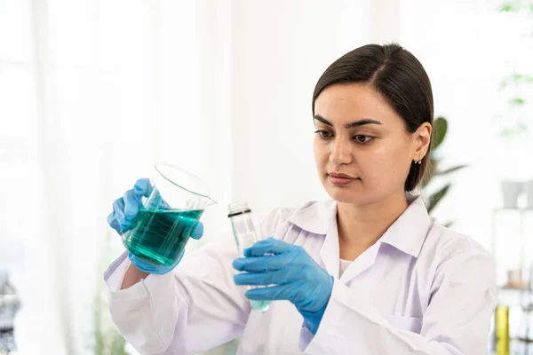 Scientist taking test tube with blue liquid, closeup. Laboratory analysis. Female science specialist laboratory working at lab to test tubes with blue liquid solution. Laboratory science concept.