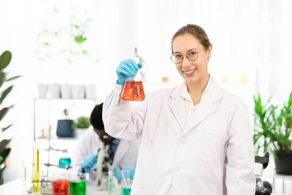 Счастливая Женщина Учёная Работает Лаборатории Улыбающаяся Ученая Женщина Красной Жидкостью — стоковое фото