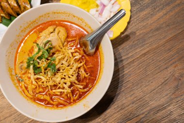 Khao Soi, Tayland eriştesi Khao Soi, ahşap zeminde baharatlı körili tavuk, Kuzey Tayland yemeği konsepti. Kuzey Tayland Körili Tavuk Eriştesi