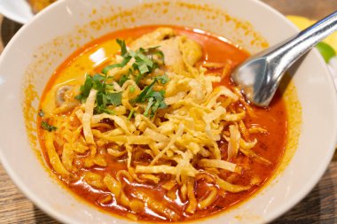 Khao Soi, Tayland eriştesi Khao Soi, ahşap zeminde baharatlı körili tavuk, Kuzey Tayland yemeği konsepti. Kuzey Tayland Körili Tavuk Eriştesi