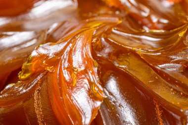 Turuncu renkli endüstriyel yağları kapatın. Metal sürtünmeyi yumuşatmak için kullanılan zengin ve kalın endüstriyel yağ dokusu. Kayganlaştırıcı yağ. Makine için sarı lityum yağı yakın çekim