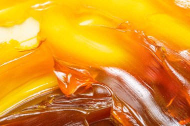 Turuncu renkli endüstriyel yağları kapatın. Metal sürtünmeyi yumuşatmak için kullanılan zengin ve kalın endüstriyel yağ dokusu. Kayganlaştırıcı yağ. Makine için sarı lityum yağı yakın çekim