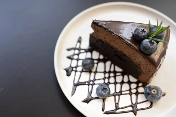Chocolate mousse cake. Its made with a chocolate cake base, cool creamy mousse filling, and topped with rich dark chocolate ganache and blueberry. Selective focus