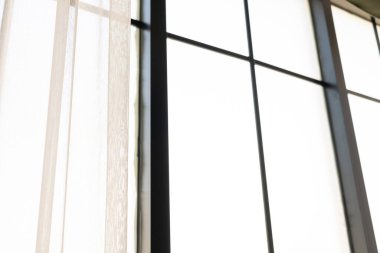 Beyaz arkaplan fotoğrafında ışık parlıyor, perdedeki gölge çizgileri, bulanık gölgeler ve duvarda sisler. Model, kopyalama alanı. Sabahın ışığı ve gölgesi.