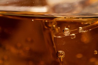 Buzlu kola. Yemek arkaplanı, kola yakın plan, tasarım elemanı. Bira köpükleri makro, buz, baloncuk, arka plan, buz küpü. Karbonatlı kola aromalı soda. 