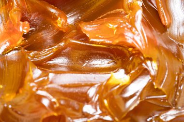 Turuncu renkli endüstriyel yağları kapatın. Metal sürtünmeyi yumuşatmak için kullanılan zengin ve kalın endüstriyel yağ dokusu. Kayganlaştırıcı yağ. Makine için sarı lityum yağı yakın çekim