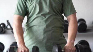 4K footage showing an unrecognizable people workout in the indoor gym, man lifting up a Hammer Curl weight exercise. bodybuilding dumbbells in gym. training in fitness gym.