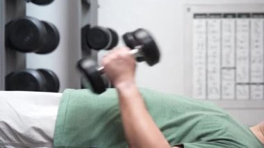 4K footage showing an unrecognizable people workout in the indoor gym, man lifting up a Hammer Curl weight exercise. bodybuilding dumbbells in gym. training in fitness gym.