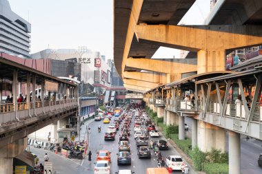 Traffic in front of Central Ladphrao Shopping Mall and Union mall with many people walking on skywalk.